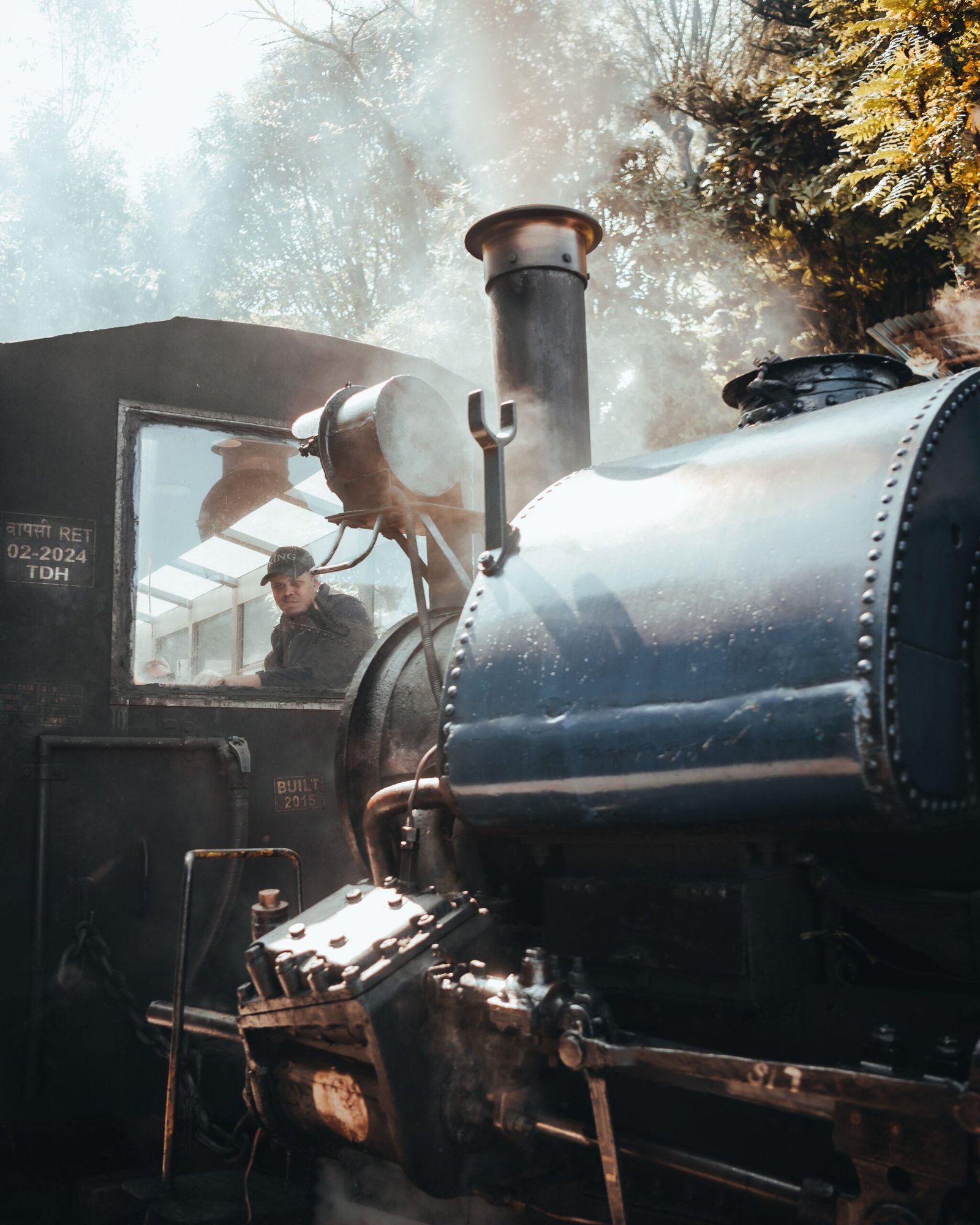 Crew preparing Darjeeling Toy Train engines at the locomotive shed in Darjeeling as onlookers watch