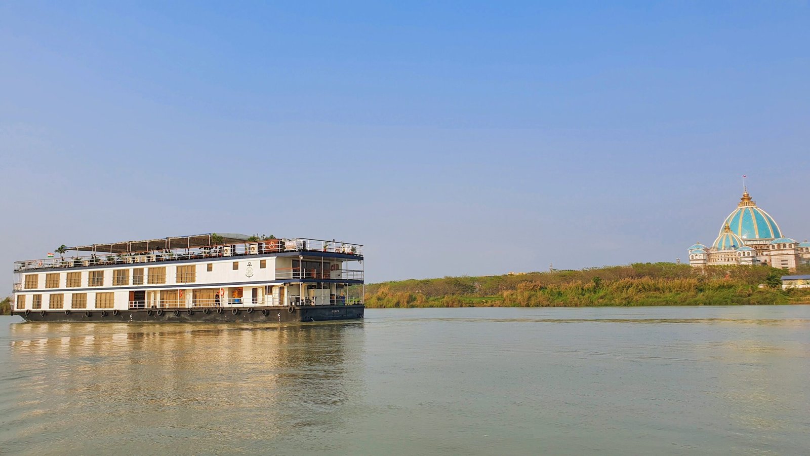 ABN Rajmahal river cruise ship sailing the Hooghly with the Mayapur temple domes in the distance